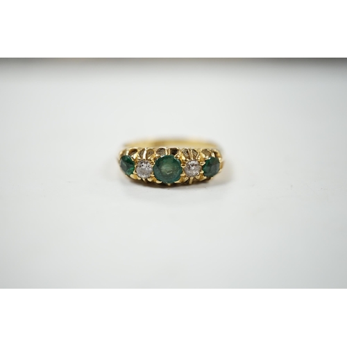 909 - An early 20th century 18ct, three stone green garnet and two stone diamond claw set half hoop ring, ... 