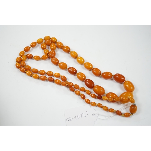 920 - A single strand graduated oval amber bead necklace, 114cm, gross weight 84 grams.