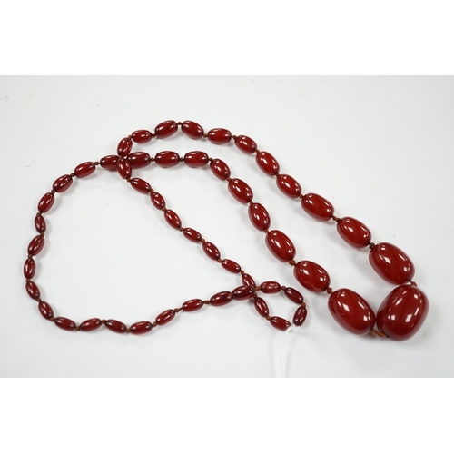 921 - A single strand graduated simulated cherry amber necklace, 88cm, gross weight 74 grams.