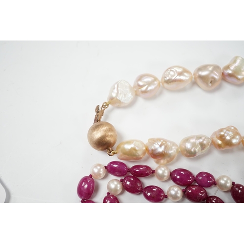 927 - A modern cultured pearl and polished ruby? bead necklace, with two stone diamond chip set 750 clasp,... 