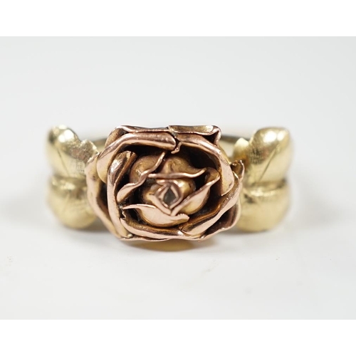 932 - A two colour 585 flower head ring, with leaf shoulders, size P/Q, 3 grams.