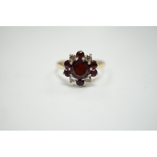 945 - An 18ct red paste? and diamond cluster set flower head ring, size M, gross weight 3.2 grams.