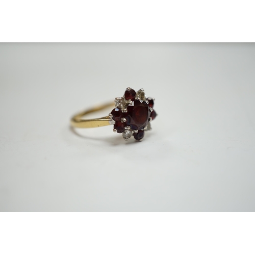 945 - An 18ct red paste? and diamond cluster set flower head ring, size M, gross weight 3.2 grams.