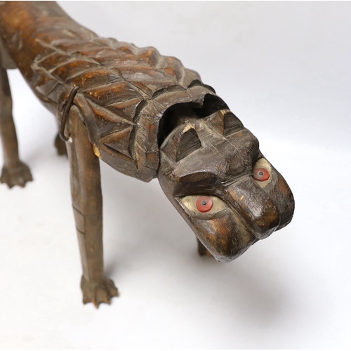 297 - An primitive African articulated wood model of a lion, 41cm wide