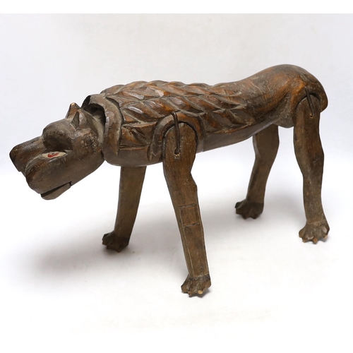 297 - An primitive African articulated wood model of a lion, 41cm wide