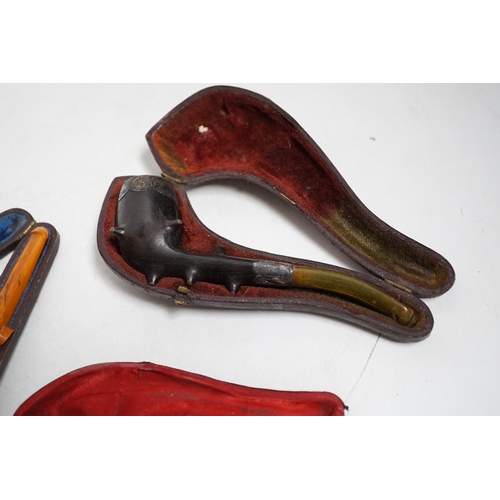 399 - Three cased pipes, one with carved amber novelty bowl, the other two with amber pipe ends, metal mou... 