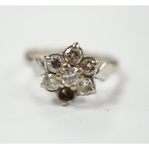 963 - An 18ct white metal and seven stone diamond cluster set flower head ring (one stone missing), size K... 