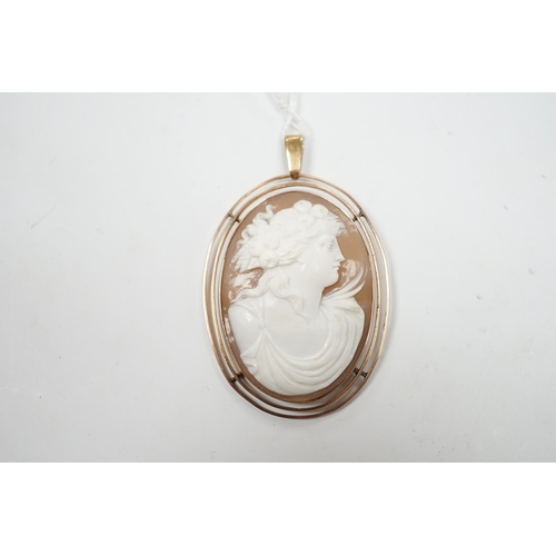 977 - An early 20th century 9ct mounted oval cameo shell pendant, carved with the bust of a lady to sinist... 