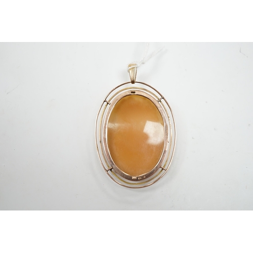 977 - An early 20th century 9ct mounted oval cameo shell pendant, carved with the bust of a lady to sinist... 