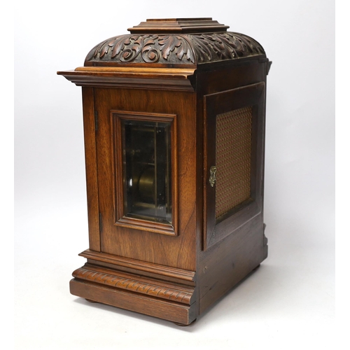 1382 - A carved walnut mantel clock with German movement, 36cm