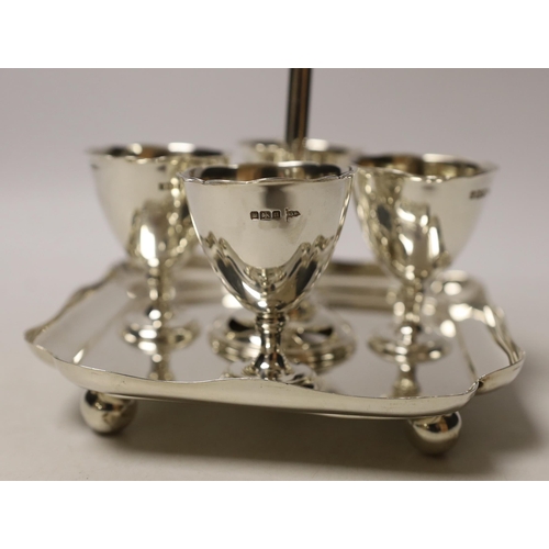 1868 - An Edwardian silver egg cruet, with loop handle and four cups, Walker & Hall, Sheffield, 1905/6, hei... 