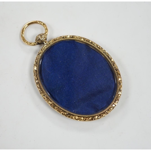 1933 - An engine turned yellow metal oval mourning locket, verso with small glazed oval panel, 56mm.