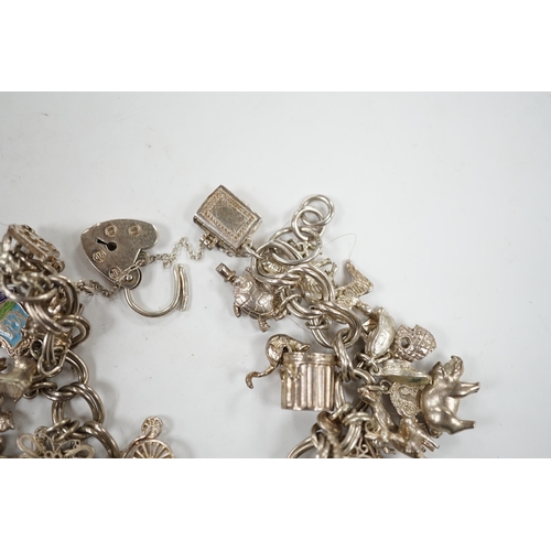 1936 - A 1970's silver charm bracelet, hung with assorted charms including birdcage, abacus, piglet, etc. a... 