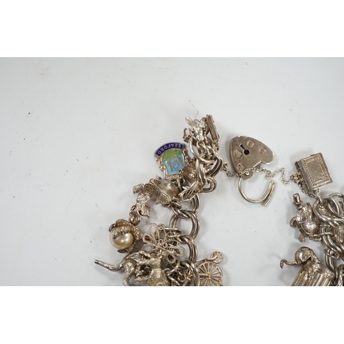 1936 - A 1970's silver charm bracelet, hung with assorted charms including birdcage, abacus, piglet, etc. a... 