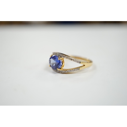 1938 - A modern 18ct gold and singe stone oval cut tanzanite ring, with diamond chip set borders, size N, g... 