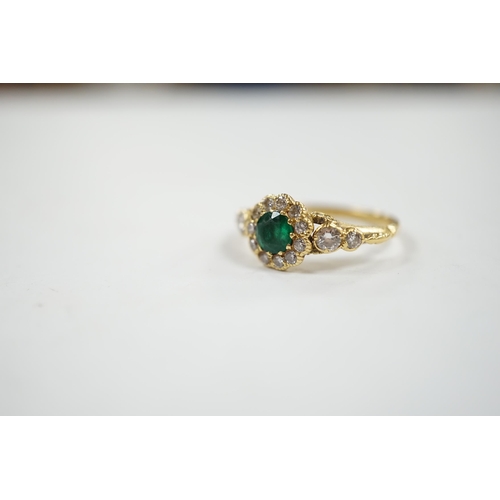 1940 - A Victorian style yellow metal emerald and diamond set circular cluster ring, with graduated diamond... 