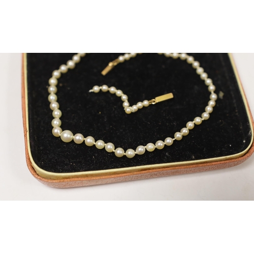 1957 - A single strand graduated cultured pearl necklace, with yellow metal clasp (a.f.), 31cm.