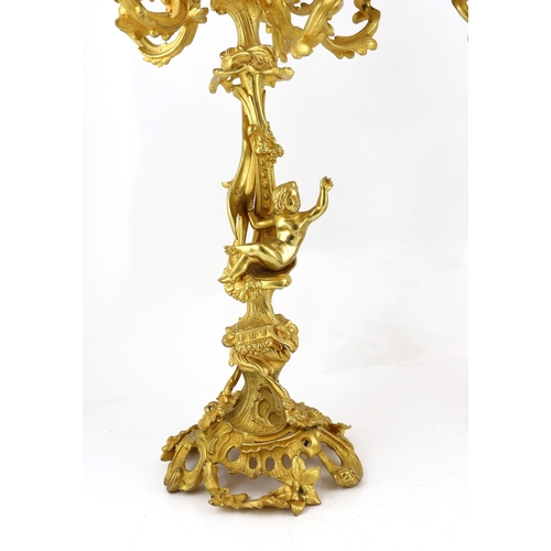 32 - A pair of Victorian style ormolu six light candelabra with rococo scroll extinguishers, scrolling br... 