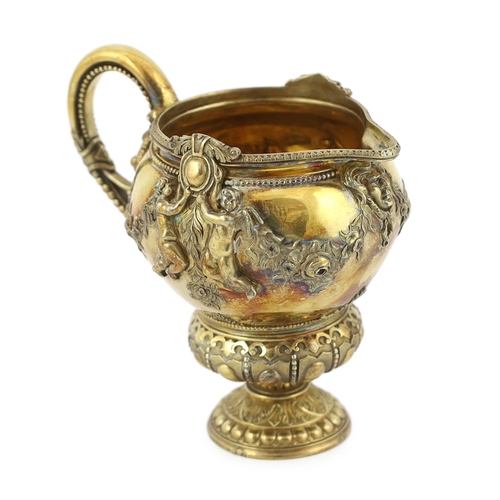 356 - An early Victorian ornate silver gilt cream jug, by George Ivory, decorated with mask, garlands of f... 