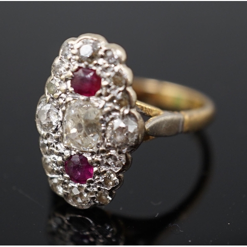 451 - An 18ct gold ruby and diamond cluster ring, the central old mine cut diamond flanked by two rubies a... 