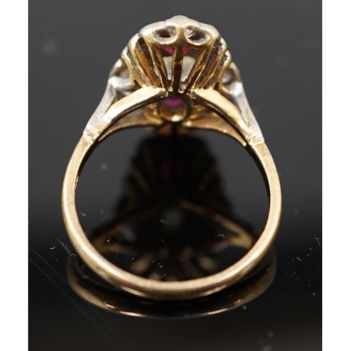 451 - An 18ct gold ruby and diamond cluster ring, the central old mine cut diamond flanked by two rubies a... 