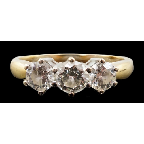 454 - A modern 18ct gold and three stone diamond set ring, the three round brilliant cut stones with a com... 