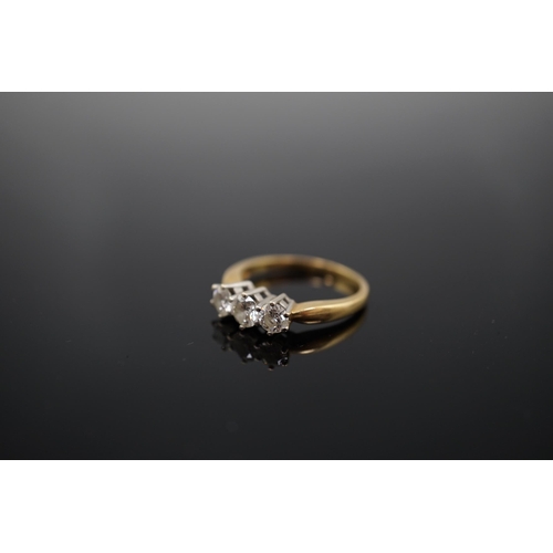 454 - A modern 18ct gold and three stone diamond set ring, the three round brilliant cut stones with a com... 