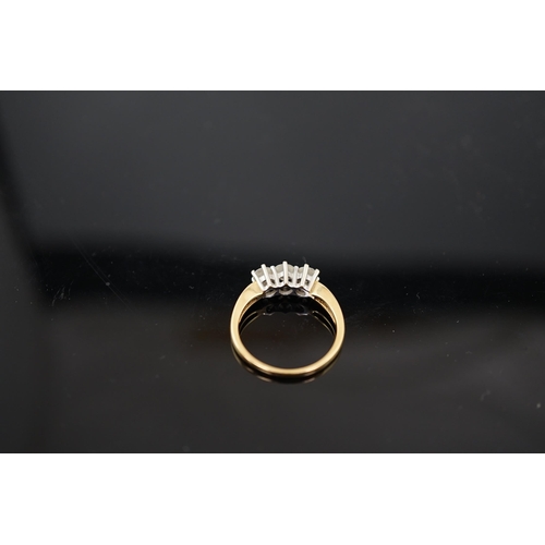 454 - A modern 18ct gold and three stone diamond set ring, the three round brilliant cut stones with a com... 