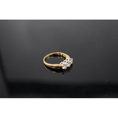 454 - A modern 18ct gold and three stone diamond set ring, the three round brilliant cut stones with a com... 