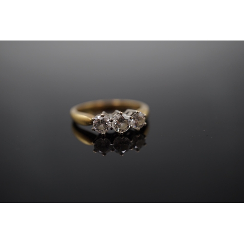 454 - A modern 18ct gold and three stone diamond set ring, the three round brilliant cut stones with a com... 