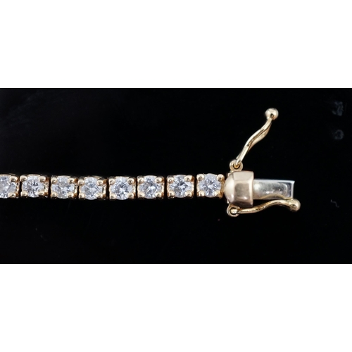 458 - A modern 18ct gold and fifty nine stone round brilliant cut diamond set line bracelet, the stones ap... 