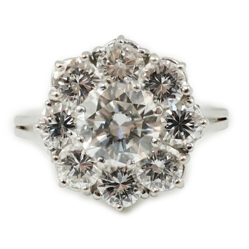 506 - A modern 18ct white gold and round brilliant cut nine stone diamond set cluster ring, the centre sto... 