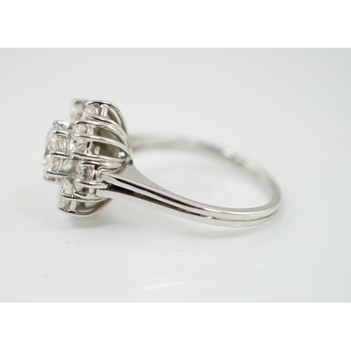 506 - A modern 18ct white gold and round brilliant cut nine stone diamond set cluster ring, the centre sto... 