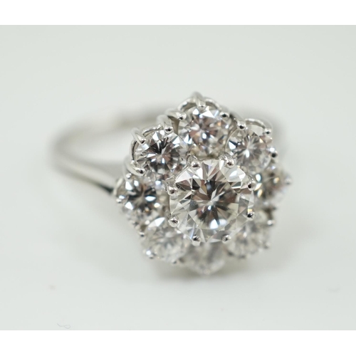 506 - A modern 18ct white gold and round brilliant cut nine stone diamond set cluster ring, the centre sto... 