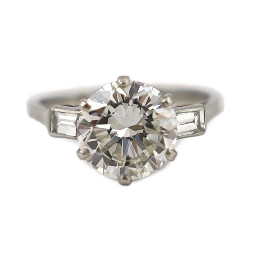 507 - A good platinum or white gold set single stone diamond ring, with two stone baguette cut diamond set... 