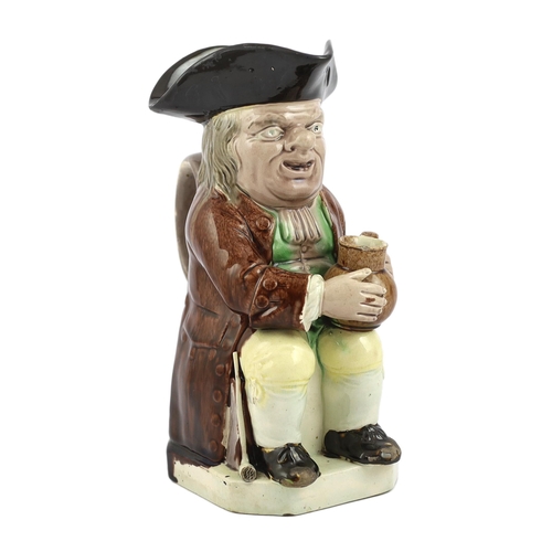 64 - A Ralph Wood type creamware Toby jug of standard type, c.1790, seated in standard pose holding an al... 