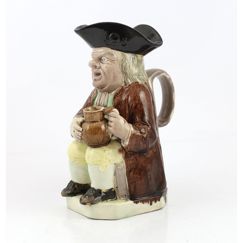 64 - A Ralph Wood type creamware Toby jug of standard type, c.1790, seated in standard pose holding an al... 