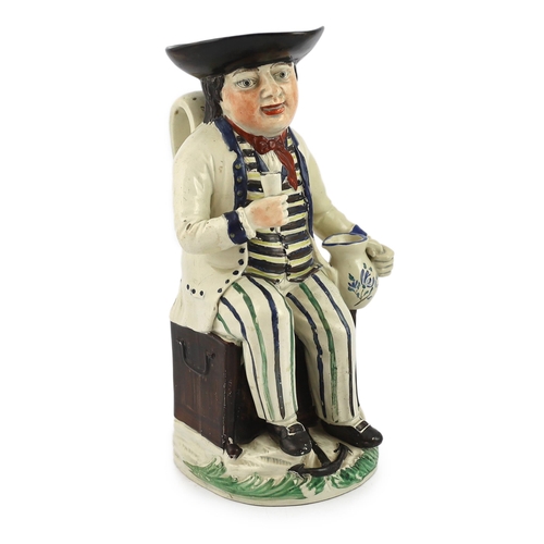 66 - A Staffordshire pearlware sailor Toby jug, c.1800-10, seated on a sea-chest, holding a cup in his ri... 