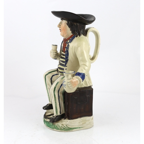 66 - A Staffordshire pearlware sailor Toby jug, c.1800-10, seated on a sea-chest, holding a cup in his ri... 