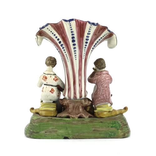 70 - A Staffordshire pearlware musical duet spill vase, c.1820, the figure of a gentleman playing the flu... 