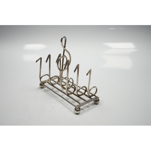 2859 - A late Victorian novelty silver toast rack, the dividers modelled as musical notes, with central han... 