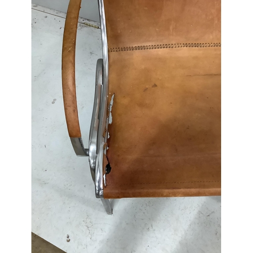 1009 - An aluminium and tan leather armchair in the  manner of Rodolf Szedleczky (seat in need of repair), ... 