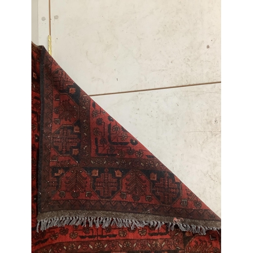 1058 - An Afghan red ground runner, 290 x 85cm