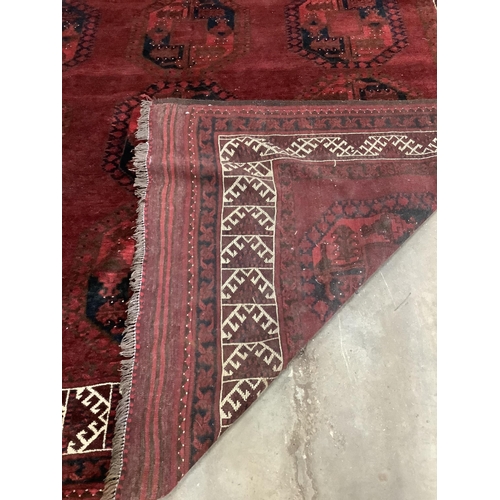 1066 - An Afghan red ground carpet, 380 x 243cm