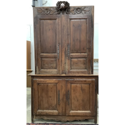 1085 - A 19th century Normandy pine marriage cupboard in two parts and carved with birds, width 141cm, dept... 