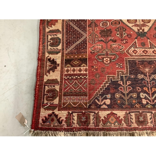 1105 - A Caucasian style red ground rug, 164 x 115cm