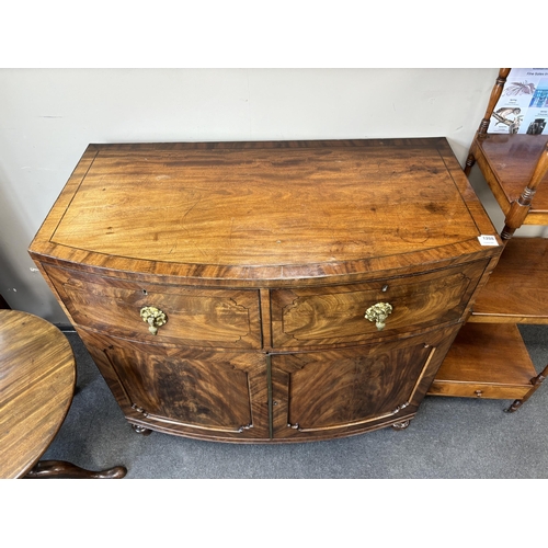 1208 - A George IV flame figured mahogany bowfront press cupboard, width 115cm, depth 61cm, height 108cm... 