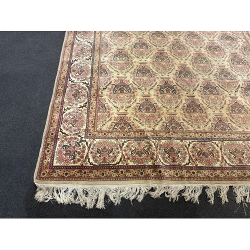 1217 - A North West Persian ivory ground carpet, woven with rows of flowering urns, 400 x 298cm