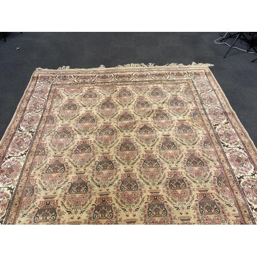 1217 - A North West Persian ivory ground carpet, woven with rows of flowering urns, 400 x 298cm