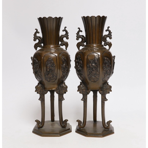 410 - A pair of Japanese bronze vases on tripod legs, 24.5cm